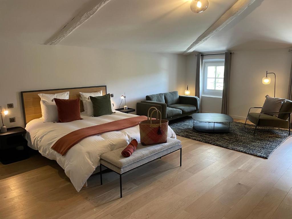 1 dormitorio con 1 cama grande y sala de estar en La Pavoyère en Mormoiron