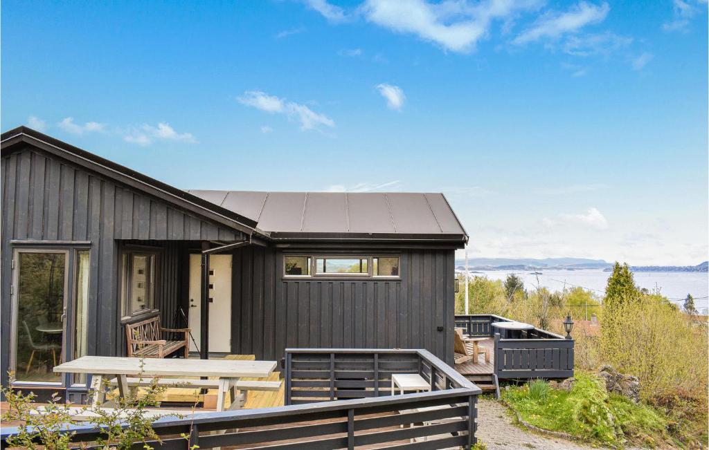 a black house with a picnic table in front of it at Amazing Home In Kopervik With Wifi And 3 Bedrooms in Kopervik