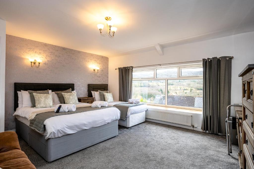 a bedroom with two beds and a window at The New Lodge in Pontardawe