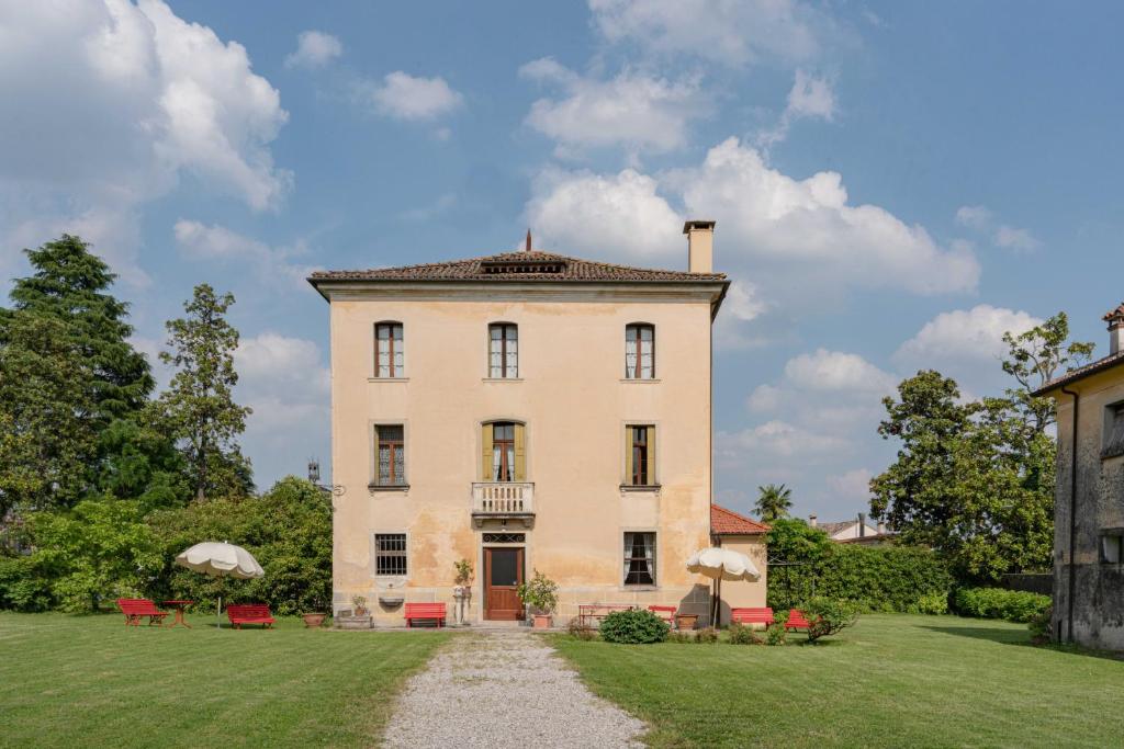 Farra di SoligoにあるFiori&vigne di Cecilia Marconの芝生の庭のある大きな白い家