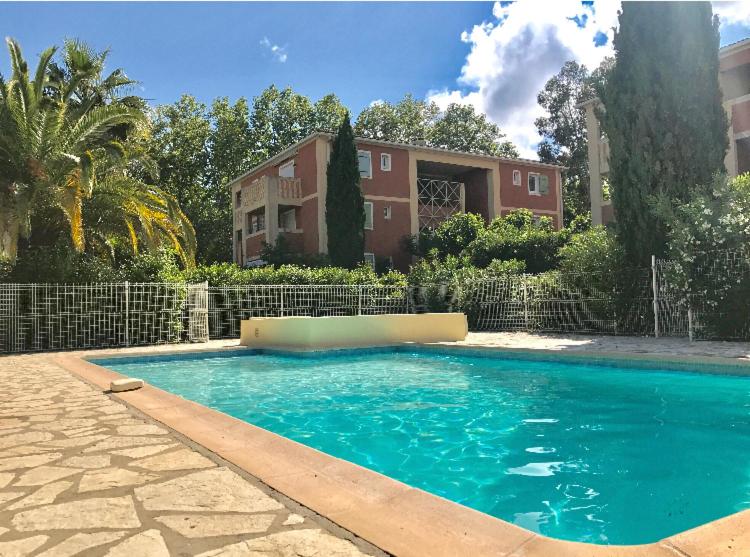 une grande piscine devant une maison dans l'établissement T2 refait à neuf, au calme, piscine, parking privé, à La Seyne-sur-Mer