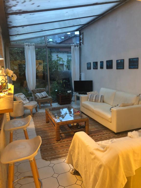 ein Wohnzimmer mit einem Sofa und einem Tisch in der Unterkunft Maison de ville avec garage in Le Mans
