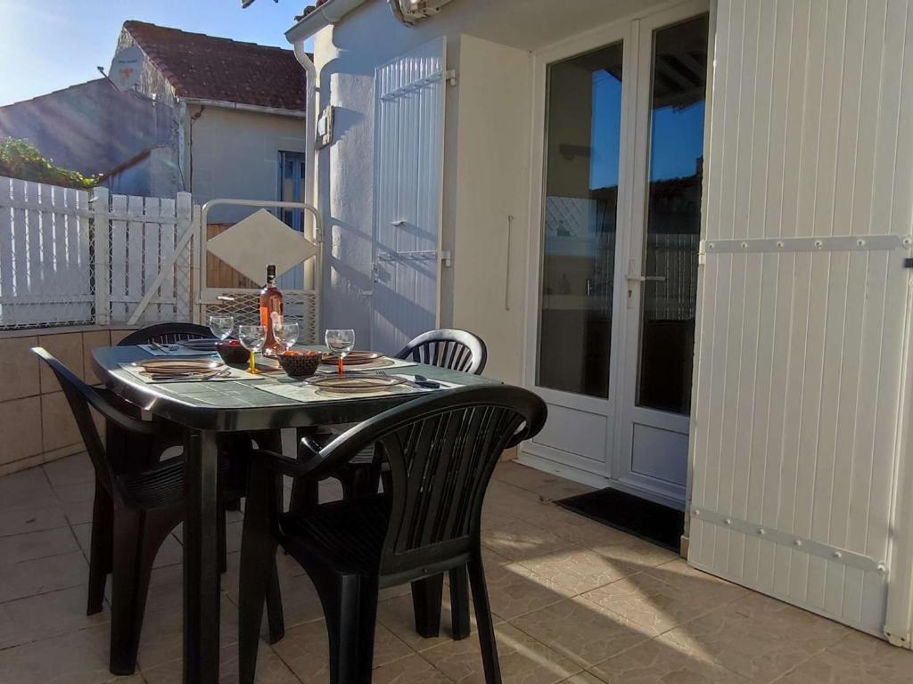 ein schwarzer Tisch und Stühle auf einer Terrasse in der Unterkunft Maison cosy au centre de La Brée-les-Bains avec 4 couchages, proche plage, WiFi gratuit - FR-1-246A-219 in La Brée-les-Bains