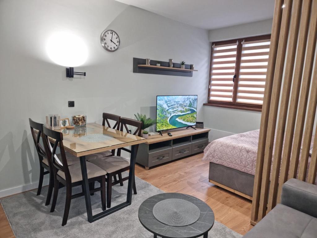 a living room with a dining room table and a bedroom at Apartman "PUZZLE" Bela Reka, Brzeće in Brzeće