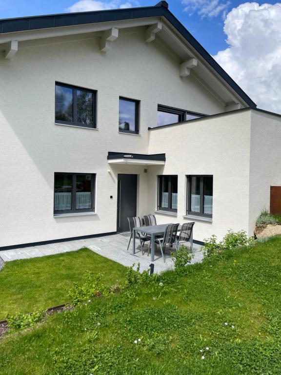 a white house with a table and chairs at Appartement Mona in Bürserberg