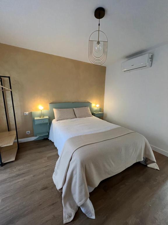 1 dormitorio con 1 cama blanca grande y 2 lámparas en Mon Rêve, en Breil-sur-Roya