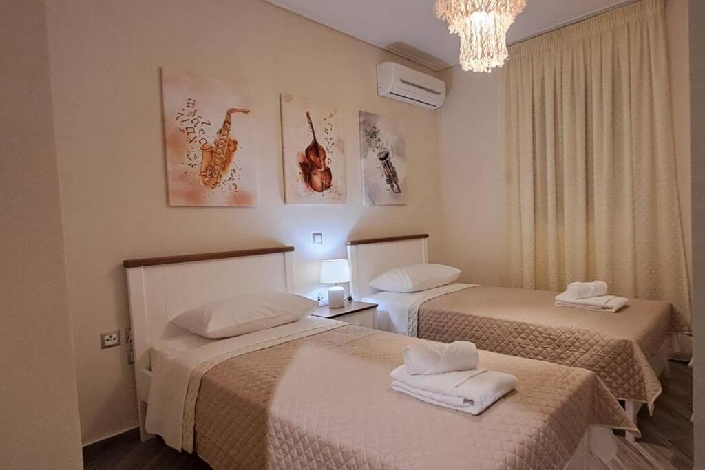 Pokój hotelowy z 2 łóżkami i żyrandolem w obiekcie Lovely Stay w Kalamácie