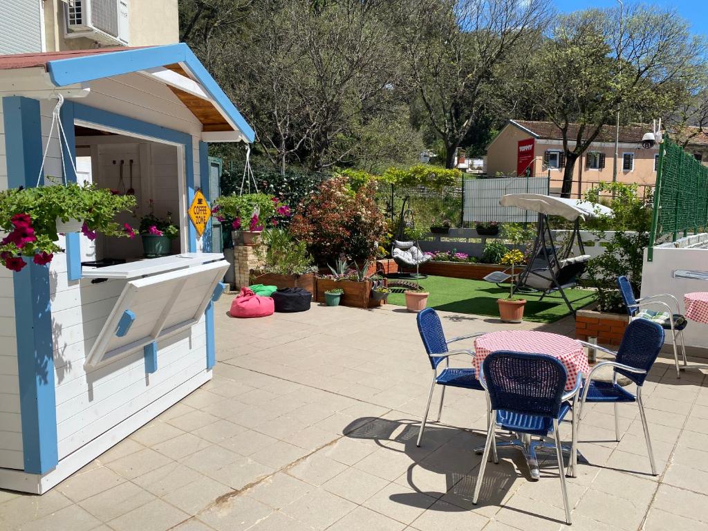 eine Terrasse mit einem Tisch und Stühlen sowie ein Gebäude in der Unterkunft Crazy House Hostel in Pula