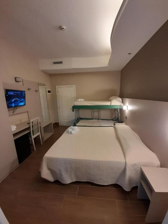 Schlafzimmer mit einem Bett, einem Schreibtisch und einem Waschbecken in der Unterkunft Hotel Royal Plaza in Rimini
