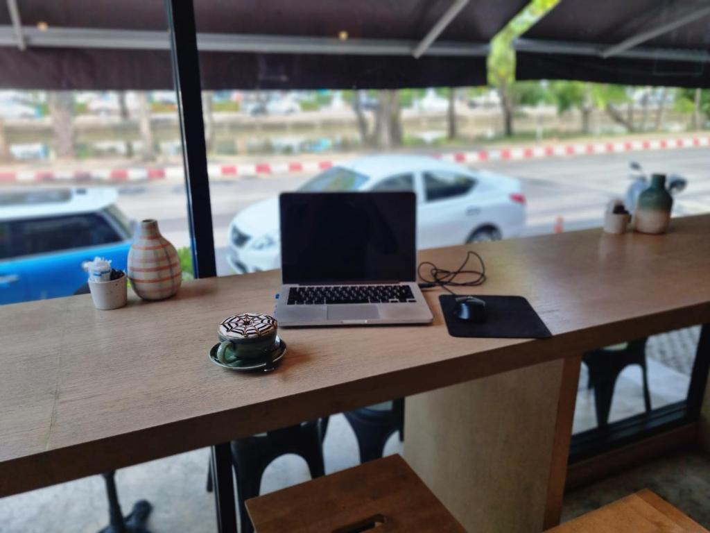 A laptop workspace at a long window-facing counter.