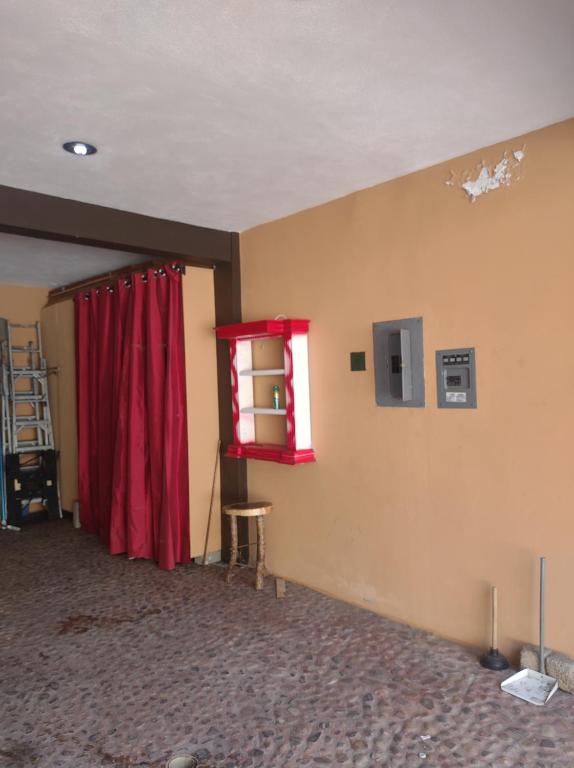 a room with a red curtain and a red window at La casita Escondida Acapulco in Acapulco