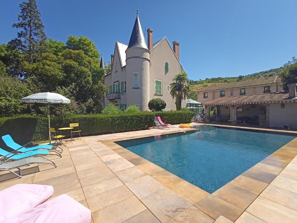 a swimming pool in front of a house at Au Fond de la Cour in Veyre-Monton