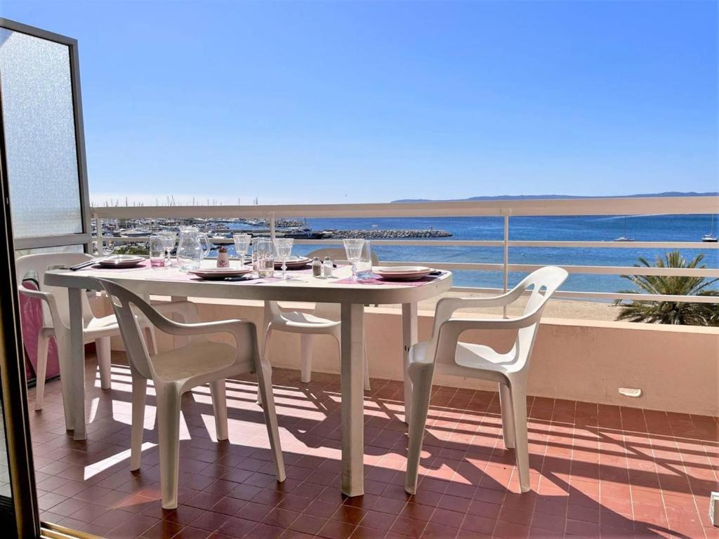 une table et des chaises sur un balcon avec vue sur l'océan dans l'établissement Appartement 2 pièces, 4 couchages, climatisé avec Wi-Fi et garage - Le Lavandou - FR-1-251-293, au Lavandou