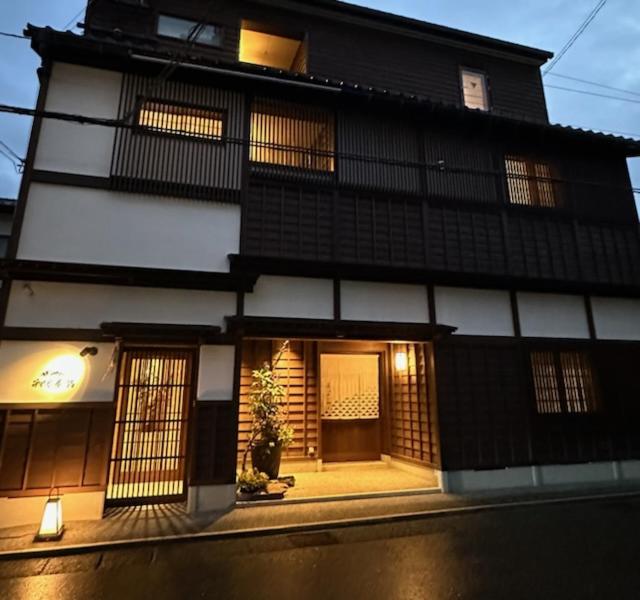 a black and white building with a front door at ひがし茶屋街らしく金沢 Hotel Rashiku kanazawa in Kanazawa