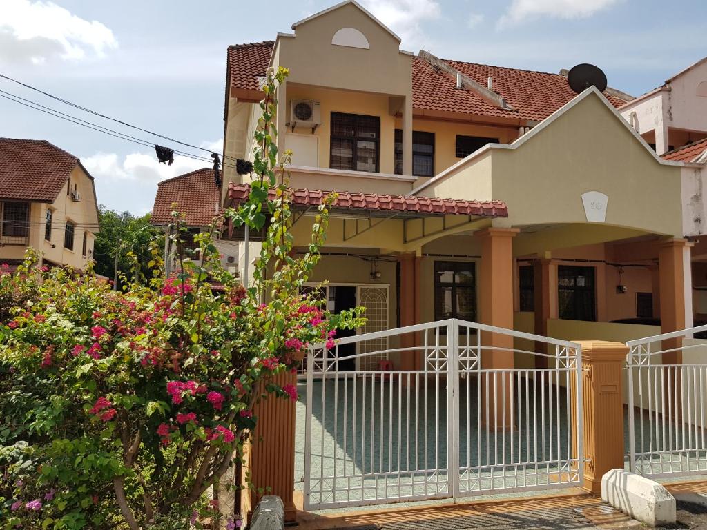 una casa con una valla blanca y flores en Homestay Melaka Bukit Beruang en Ayer Keroh