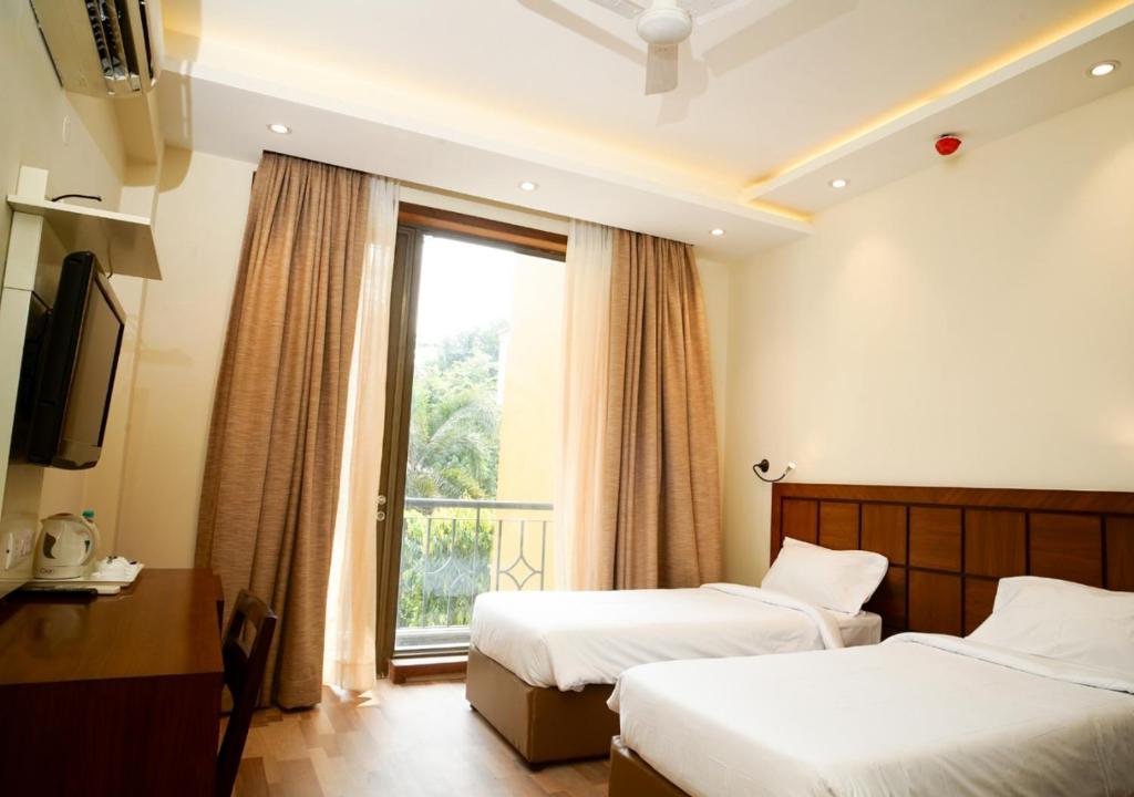 a hotel room with two beds and a window at UDS Villa - Scandinavian B&B in New Delhi
