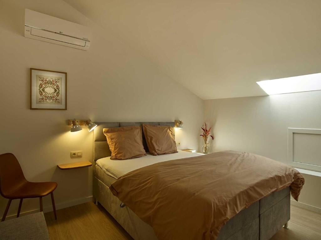 um quarto com uma cama grande e uma cadeira em lit-loo em Hasselt