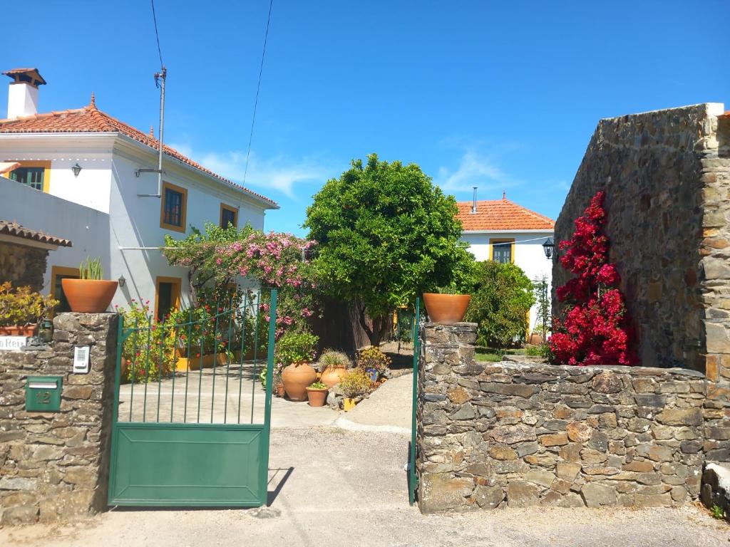 un cancello in un muro di pietra di fronte a una casa di O Ninho do Rei a Vila de Rei