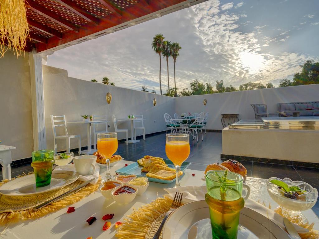 een tafel met eten en drinken op een patio bij Riad Princesse Du Désert & Spa in Marrakesh