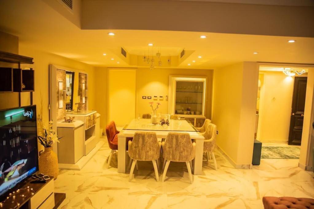 a kitchen and dining room with a table and chairs at Jood Residences Apartment in Cairo