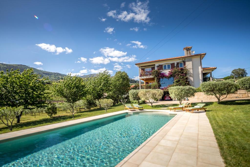 a villa with a swimming pool in front of a house at La Rosière in Peso da Régua