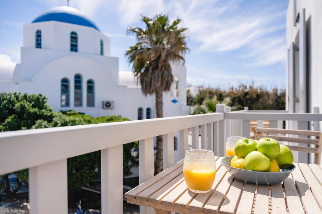 a bowl of fruit and a glass of orange juice on a balcony at Afluencia Complex Studio No 4,5,6 in Naousa