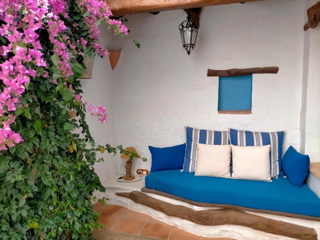 a blue couch on a patio with pink flowers at Albaga in Sant Jordi