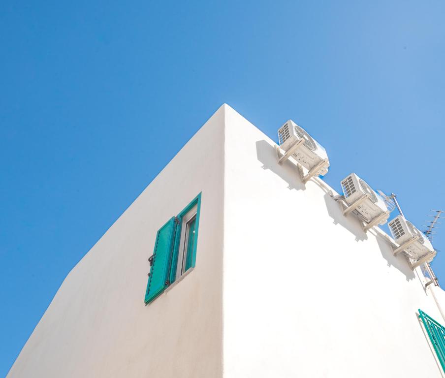 een wit gebouw met groene ramen en blauwe lucht bij La Casa Turquesa in Águilas