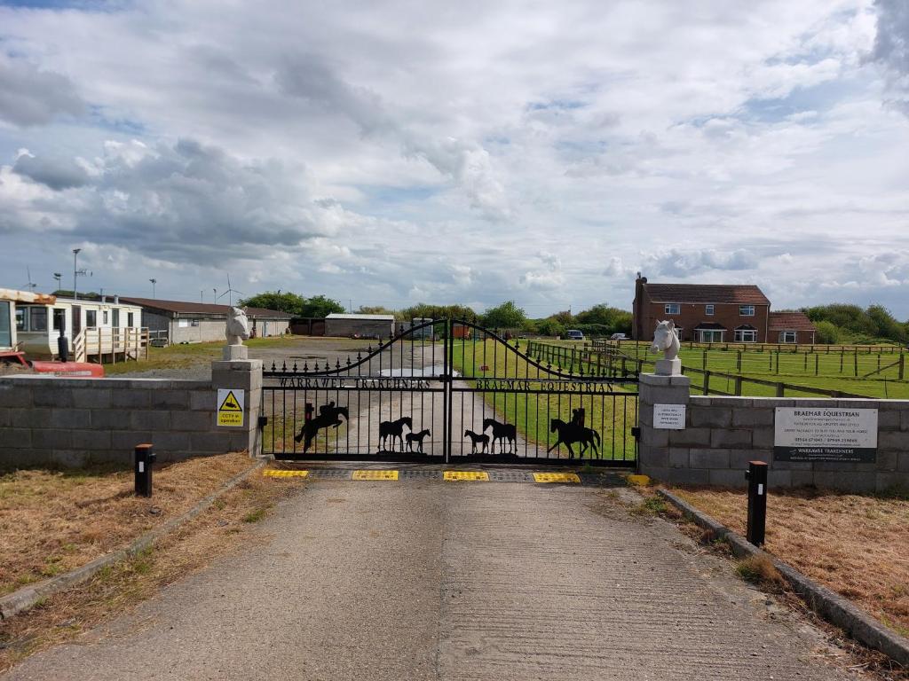 a gate with animals painted on it in a field at Braemar Equestrian, East Riding of Yorkshire in Burton Pidsea