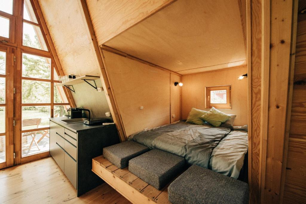 a bedroom with a bed in a tiny house at Ábrahám Cabin House in Ábrahámhegy