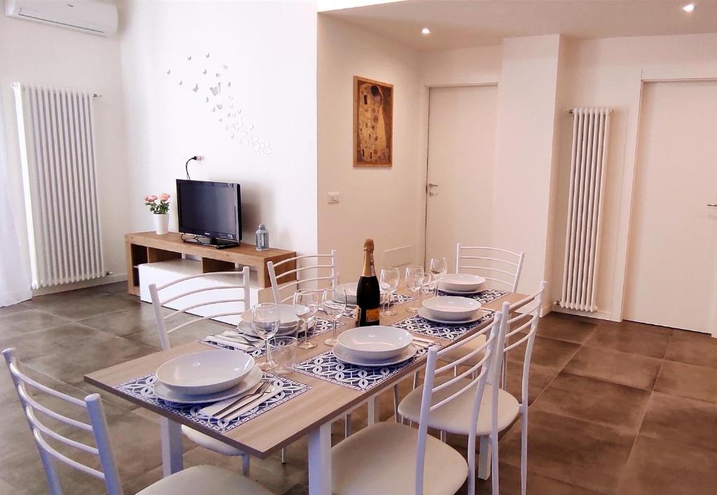 a dining room with a table with chairs and a bottle of wine at Lux Family Apartment in Bardolino