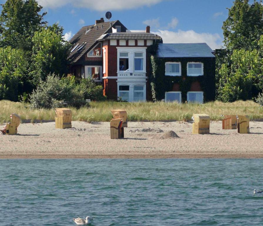 una casa sulla spiaggia con un'anatra nell'acqua di Haus Memel a Niendorf