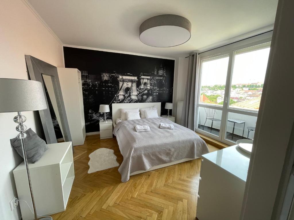 1 dormitorio con cama y ventana grande en PANORAMIC FAMILY APT with FREE TWO PARKING PLACE AND BREAKFAST, en Budapest