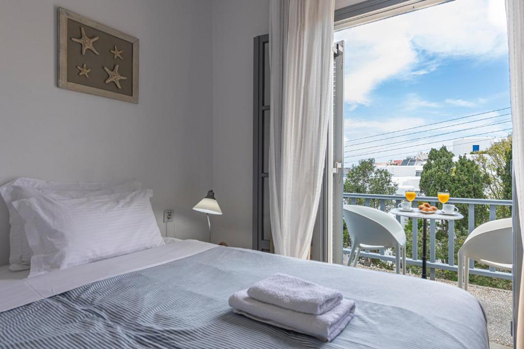 a bedroom with a bed and a balcony with a view at Hotel Manto in Naousa