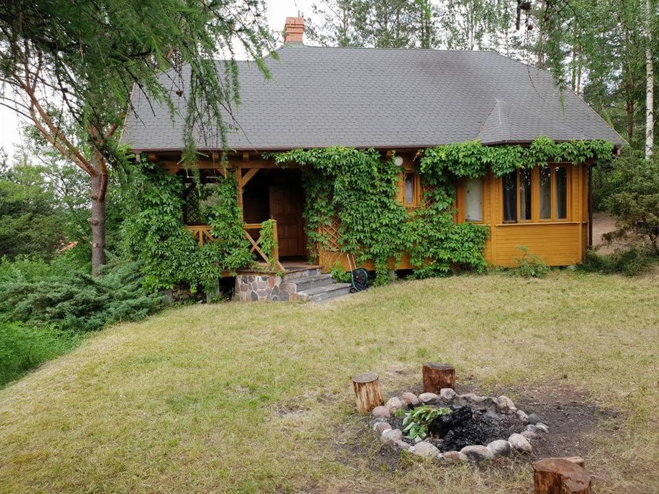 een huis met een vuurplaats ervoor bij Dom nad Jeziorem Wigry Suwalszczyzna in Gawrych Ruda