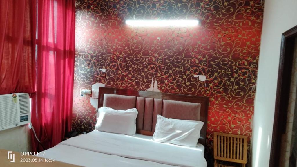 a bedroom with a bed with a red wall at Hotel Diamond palace 45C in Chandīgarh