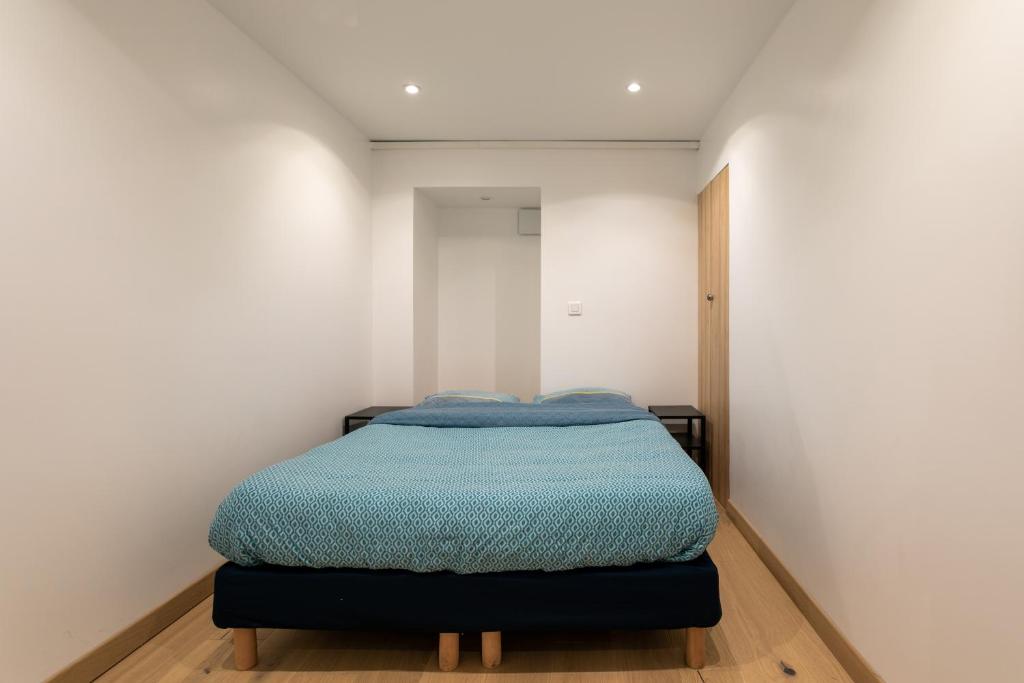 - une chambre avec un lit doté d'une couverture bleue dans l'établissement Superbe appartement Hamelin Paris 16eme, à Paris