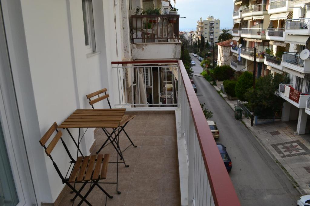 balkon z 2 krzesłami i stołem na balkonie w obiekcie Kalamaria brand new 1 bedroom apartment w Salonikach