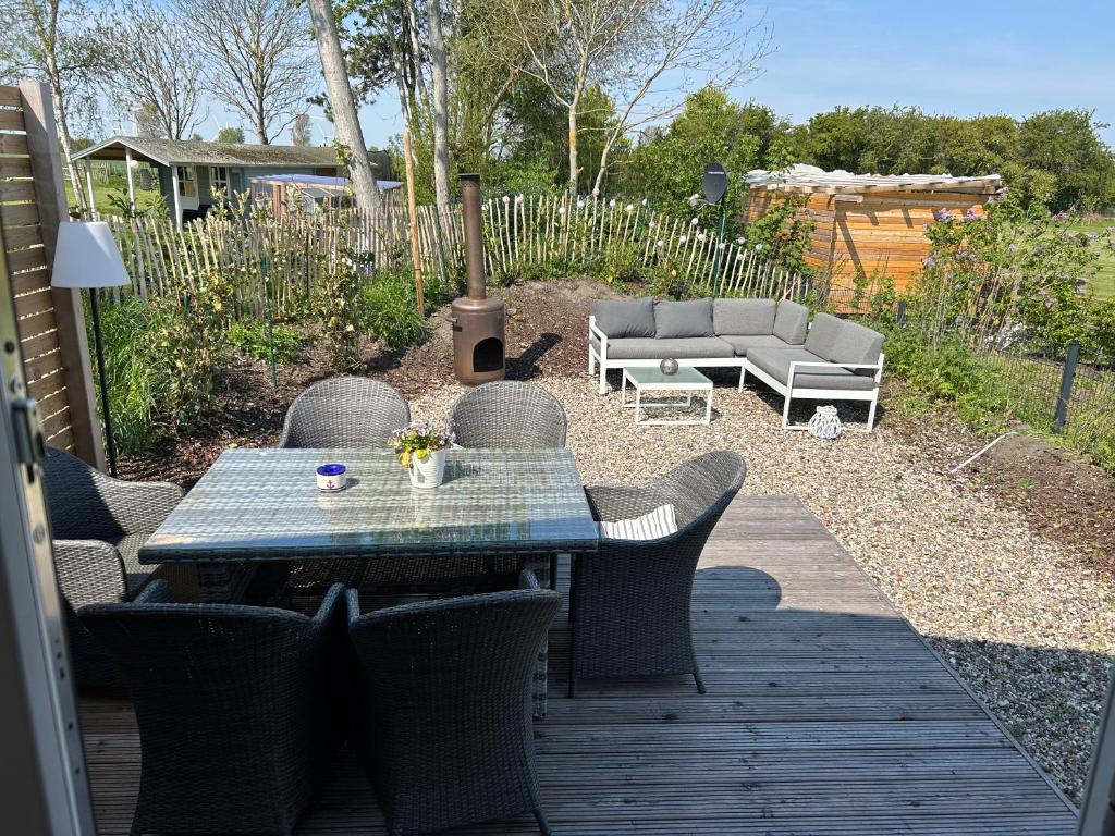 a patio with a table and chairs and a couch at Ferienhaus Feldblick in Fehmarn