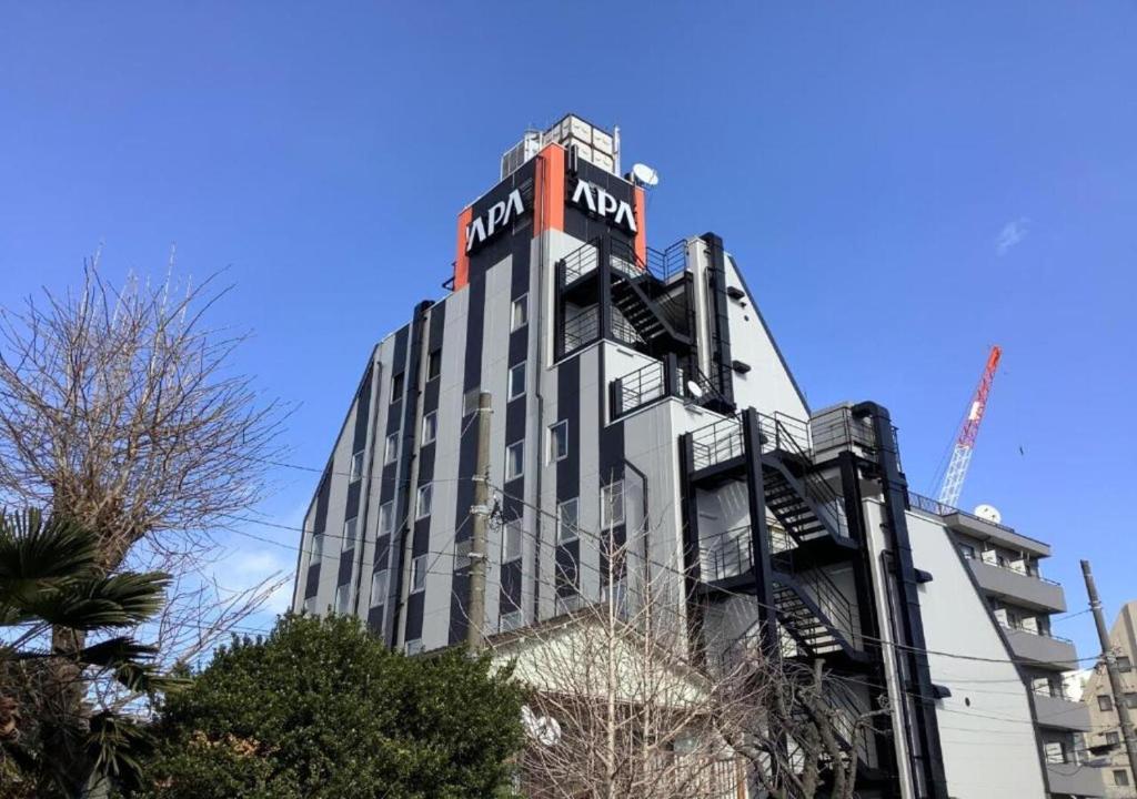 a building with a sign on the top of it at APA Hotel Hachioji Eki Kita in Hachioji