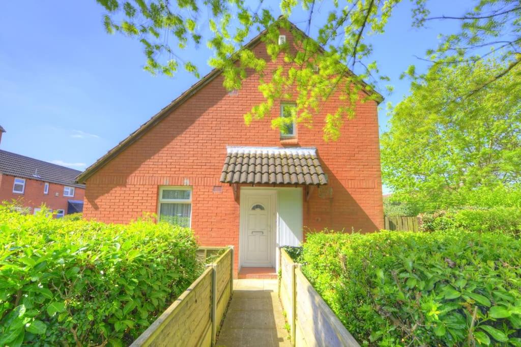 una casa di mattoni rossi con una porta bianca di Park View - sleeps 7 great for 5 contractors a Warrington
