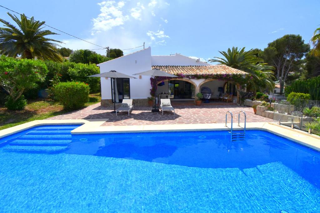 una villa con piscina frente a una casa en Casa Markoli, en Jávea
