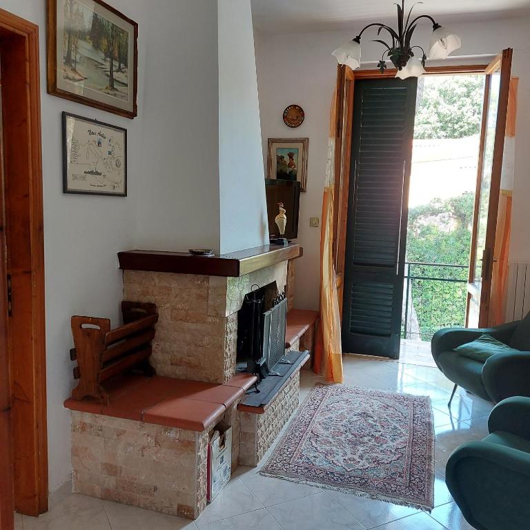 uma sala de estar com uma lareira de tijolos e uma porta em Appartamento a due passi dal mare a Quercianella em Quercianella