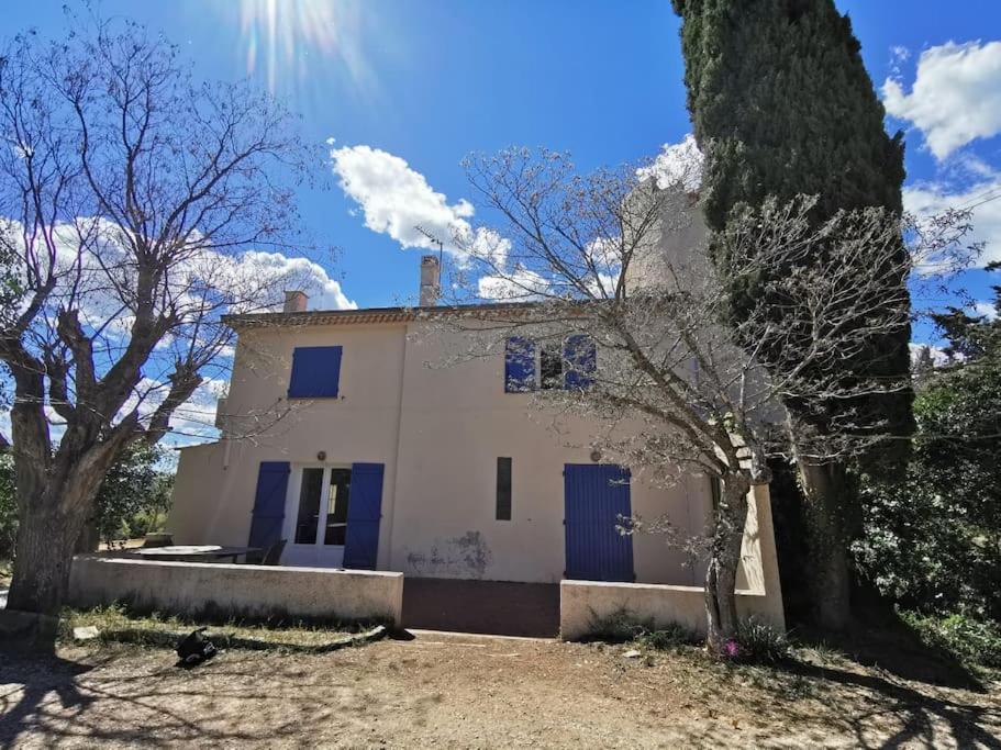 a white house with blue doors and trees at Maison a la campagne entre Aix en Pce et Marseille in Les-Pennes-Mirabeau