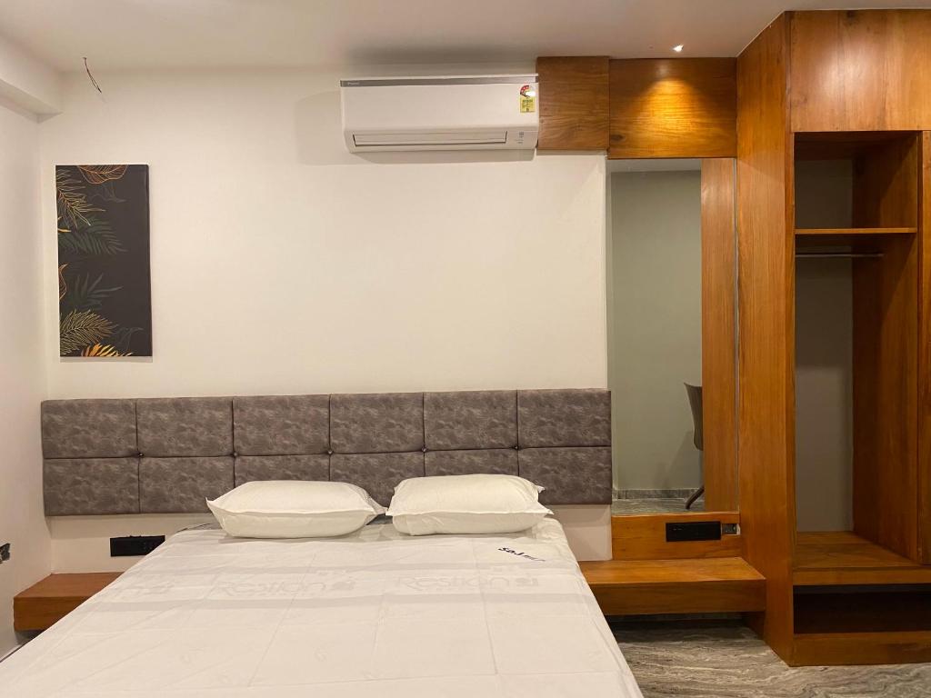 a bedroom with a bed and a air conditioner at Luxe Inn in Kannur