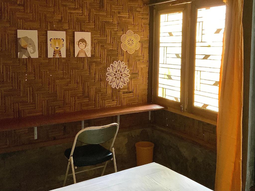 a chair sitting in a room with a window at Homestay Bukit Lawang in Bukit Lawang