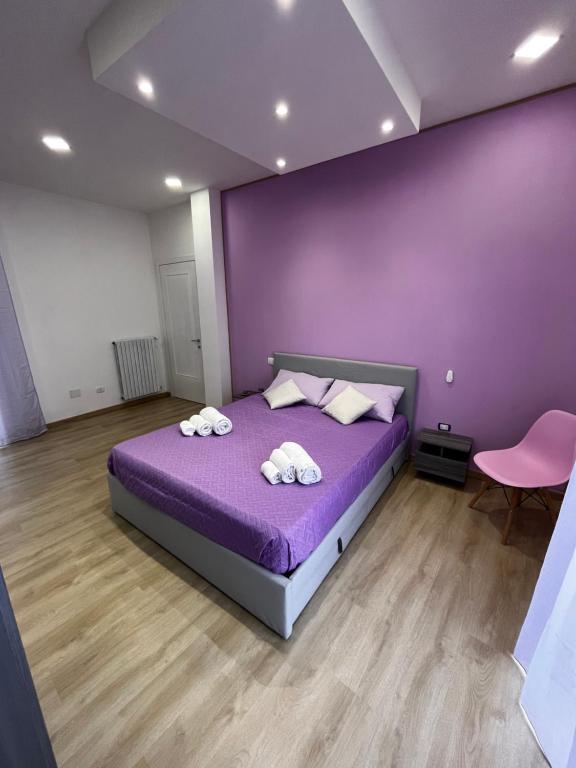 - une chambre violette avec un lit et 2 serviettes dans l'établissement Renovated Loft with Vesuvio view terrace, à Scafati
