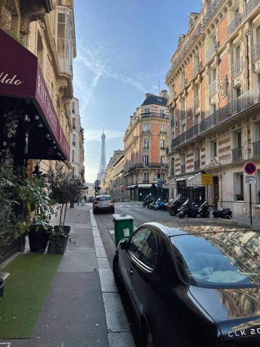 une voiture noire garée dans une rue urbaine abritant des bâtiments dans l'établissement Appartement paris 16 eme, à Paris
