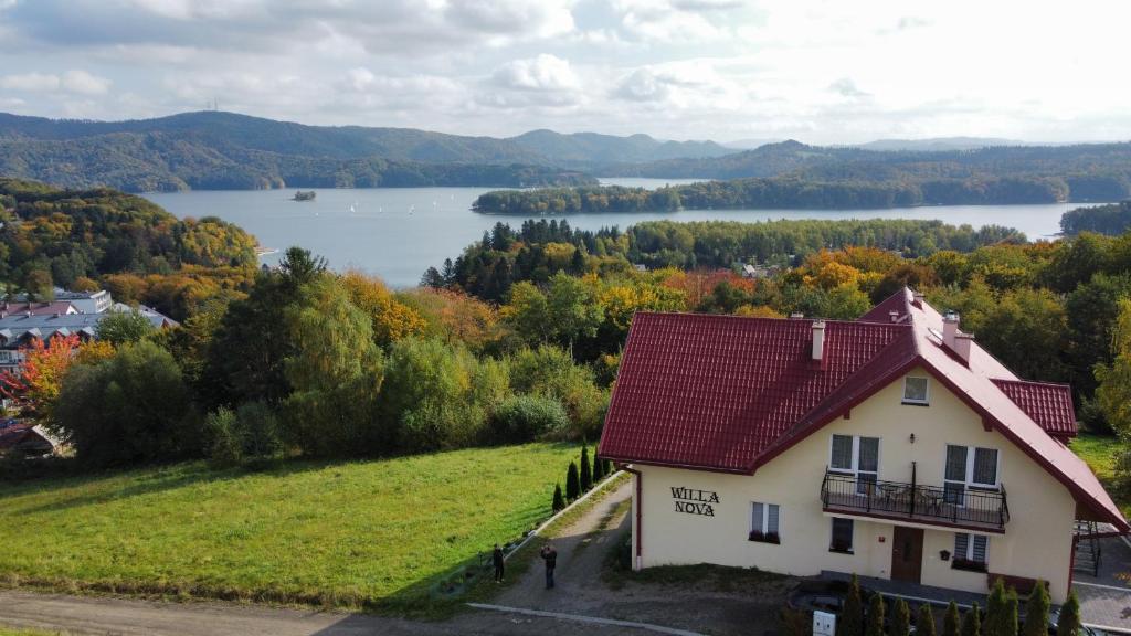 una casa en una colina con vistas a un lago en Willa Nova, en Polańczyk