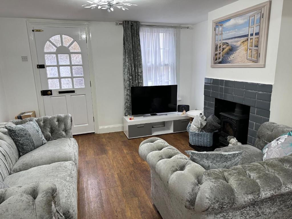 a living room with two couches and a fireplace at 14 crouch road in Burnham-on-Crouch